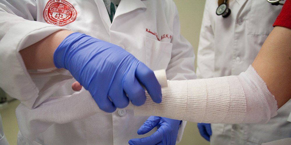 Doctor wrapping patient's arm in gauze
