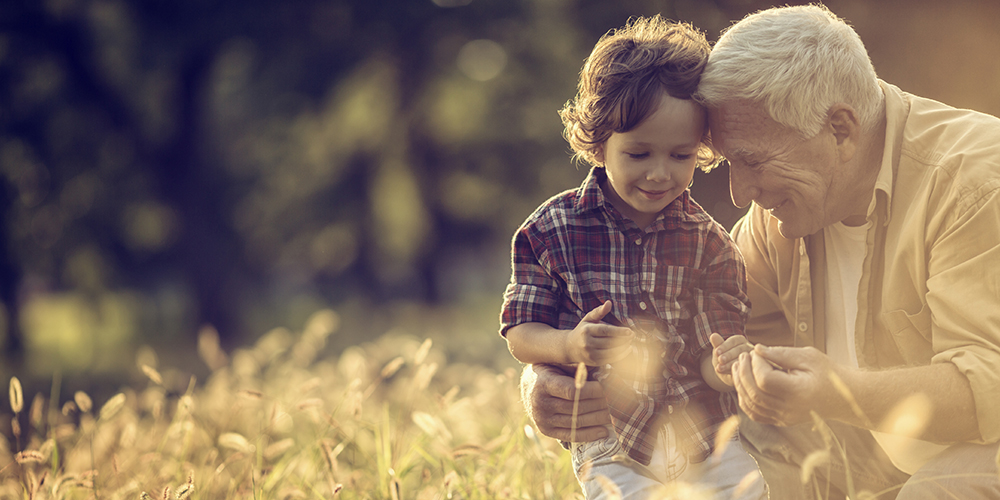 grandfather with grandson in a field